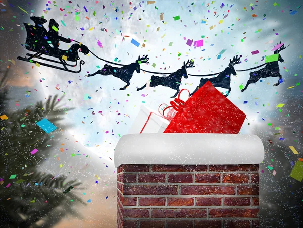 Santa flying behind chimney — Stock Photo, Image