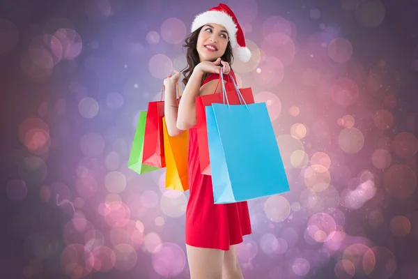 Imagem composta de morena festiva segurando sacos de compras — Fotografia de Stock