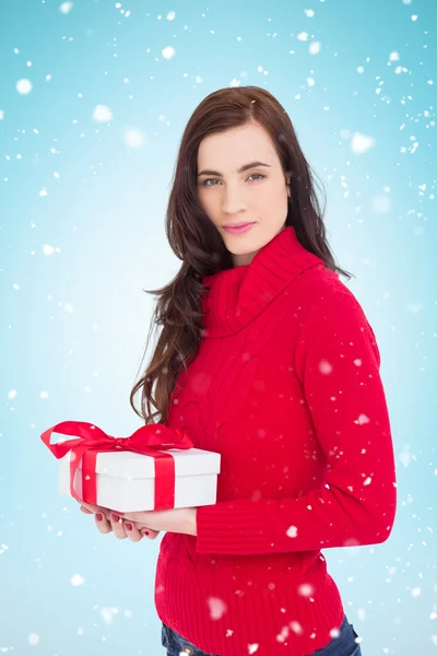 Brunette in red jumper hat holding gift — Stock Photo, Image