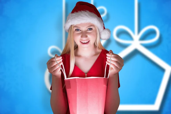 Composite image of festive blonde opening a gift bag — Stock Photo, Image