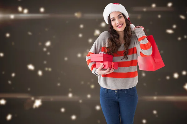 Složený obraz úsměvu bruneta drží dary a ukazující sh — Stock fotografie