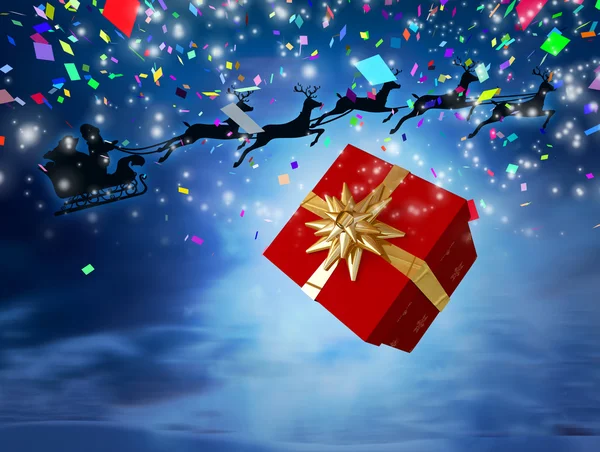 Santa flying achter groot cadeau — Stockfoto