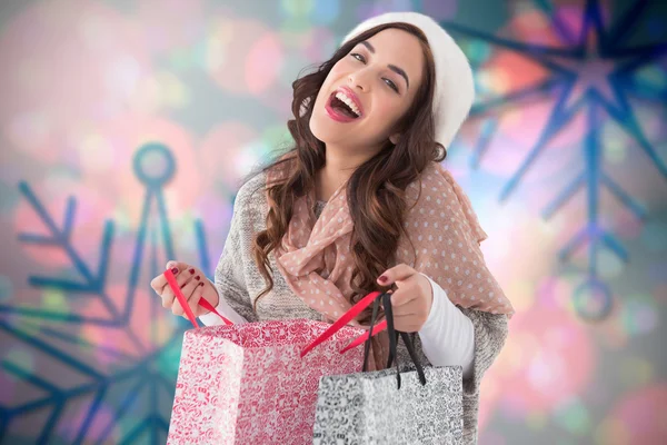 Composite image of happy brunette opening shopping bag — Stock Photo, Image