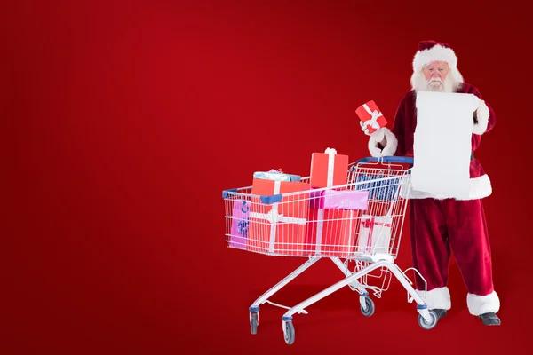 Santa verspreiding presenteert met winkelwagen — Stockfoto