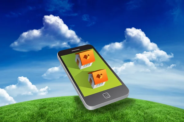 Houses on smartphone against green field — Stock Photo, Image