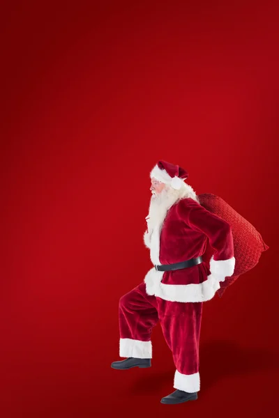Weihnachtsmann springt mit seiner Tasche — Stockfoto