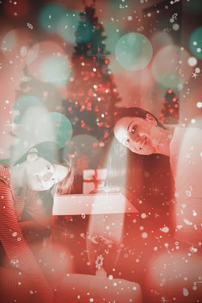 Festive mother and daughter opening a glowing — Stock Photo, Image