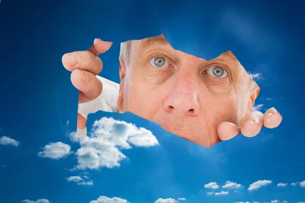 Composite image of older man looking through rip — Stock Photo, Image