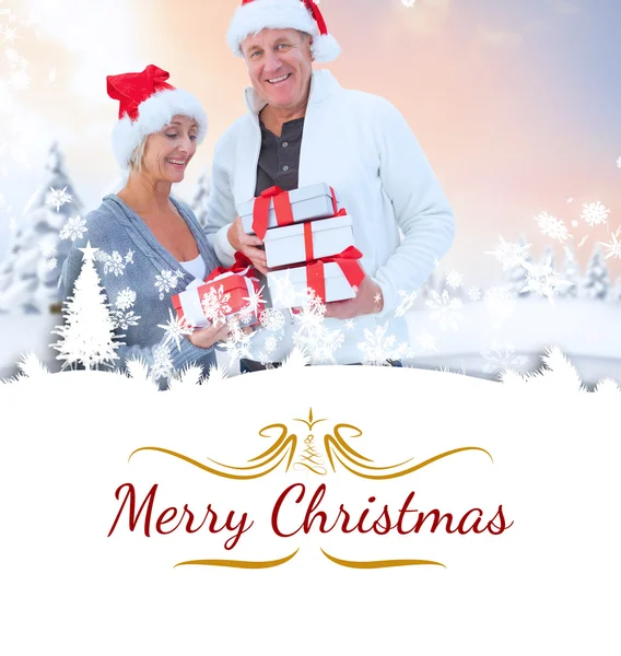 Mature couple holding christmas gifts — Stock Photo, Image