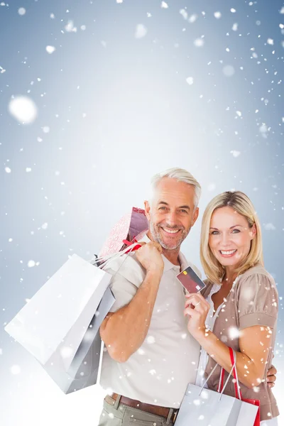 Pareja con bolsas de compras y tarjeta de crédito — Foto de Stock