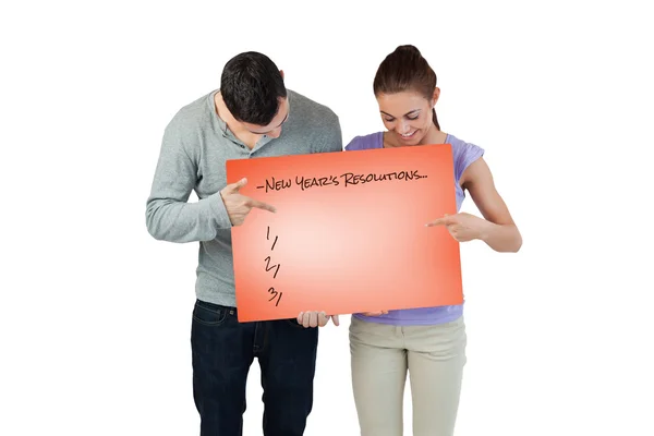 Young couple pointing at banner — Stock Photo, Image