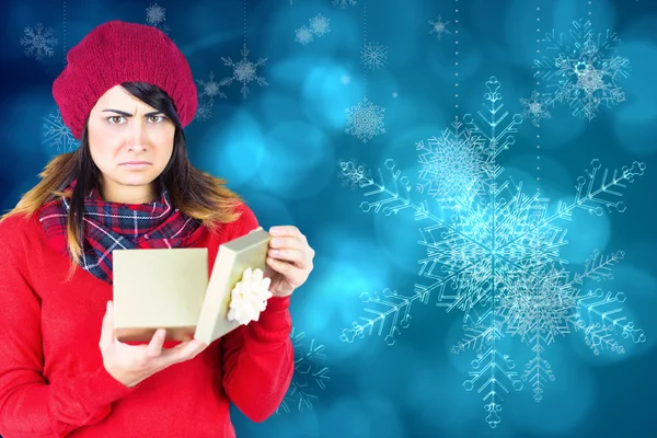 Unhappy brunette opening christmas gift — Stock Photo, Image