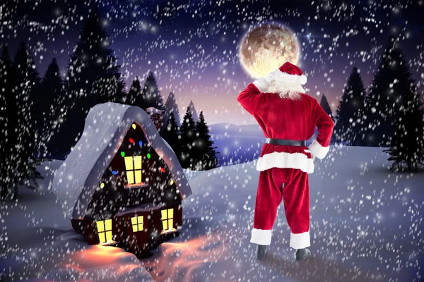 Santa Claus mot jul house — Stockfoto