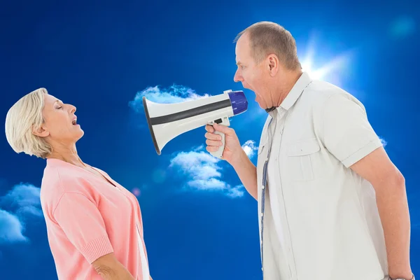 Человек кричит на своего партнера через мегафон — стоковое фото