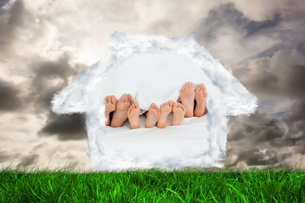 Famille sur le lit à la maison avec leurs pieds — Photo