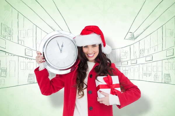 Brune festive tenant une horloge et un cadeau — Photo