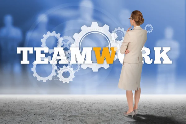 Thinking businesswoman against teamwork text — Stock Photo, Image