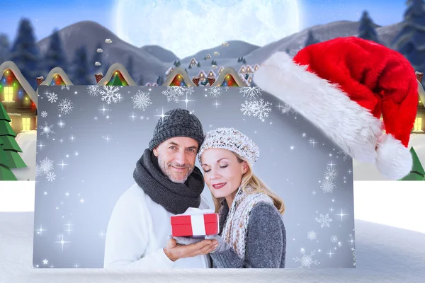 Bild eines glücklichen Winterpärchens mit Geschenk — Stockfoto