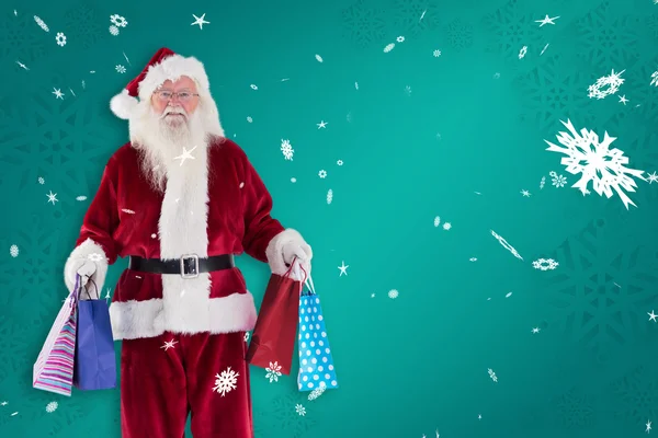Weihnachtsmann trägt ein paar Weihnachtstüten — Stockfoto