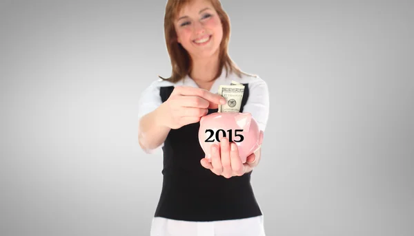 Vrouw zet geld in een spaarvarken bank — Stockfoto