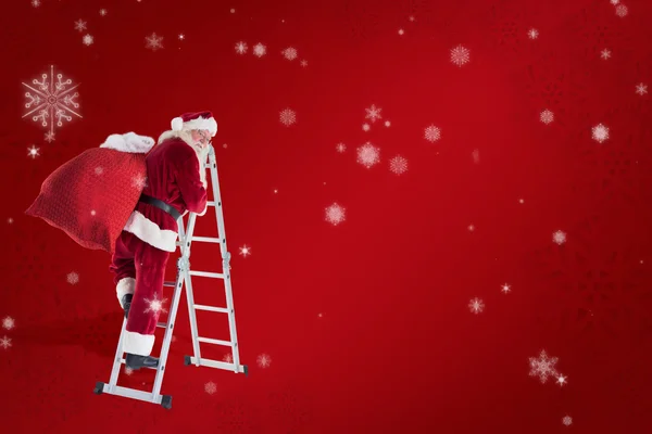 Санта поднимается по лестнице — стоковое фото