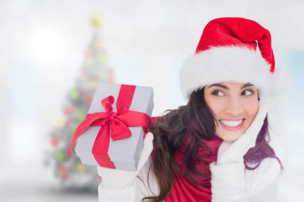 Bruna sorpresa in cappello di Babbo Natale in possesso di regalo — Foto Stock