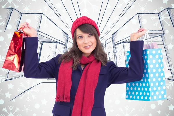 Brunette holding up shopping bags — Stock Photo, Image