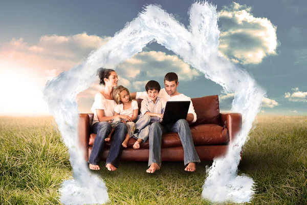 Happy family using the laptop in a field — Stock Photo, Image