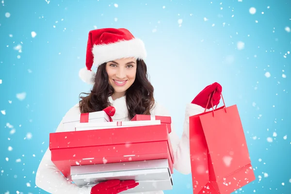 Festive brunette holding christmas gifts — Stock Photo, Image