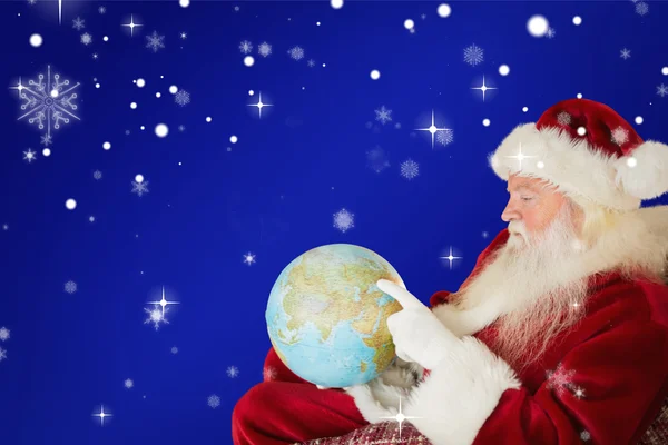 Jultomten pekar på globe — Stockfoto