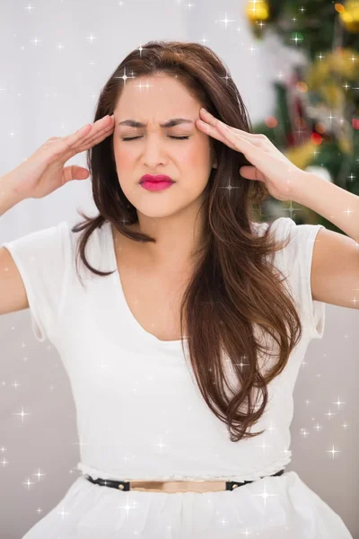 Brunette getting a headache on christmas day — Stock Photo, Image