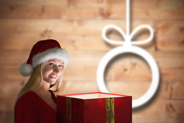 Zusammengesetztes Bild einer festlichen Blondine mit einem Geschenk — Stockfoto