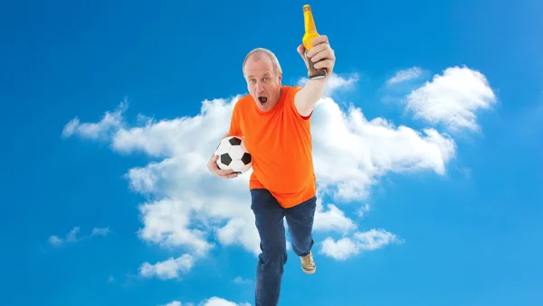 Mature man in orange tshirt holding football — Stock Photo, Image