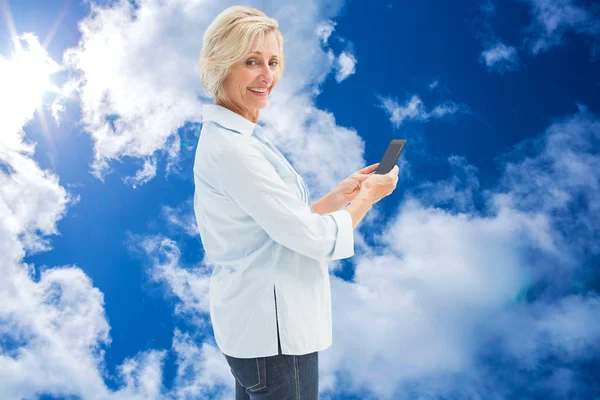 Happy mature woman sending a text — Stock Photo, Image