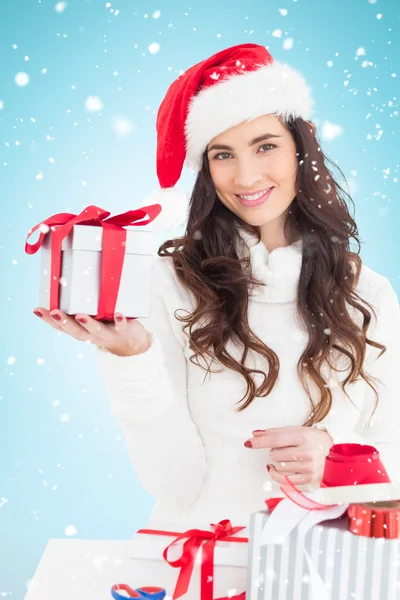 Bruna allegra in cappello di Babbo Natale in possesso di regalo — Foto Stock