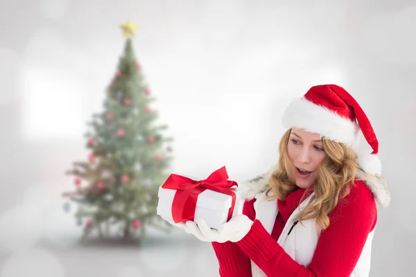 Překvapený blondýna v santa hat drží dárek — Stock fotografie