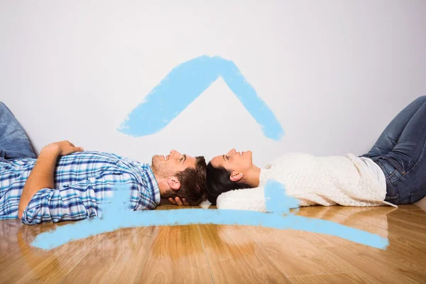 Jovem casal deitado no chão sorrindo — Fotografia de Stock