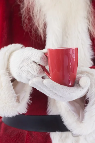 Santa sostiene una taza roja —  Fotos de Stock