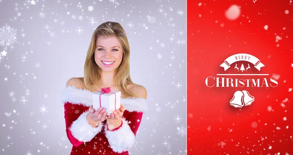 Girl in santa outfit holding gift — Stock Photo, Image