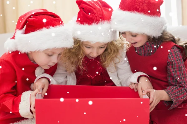 Petits frères et sœurs festifs regardant le cadeau — Photo