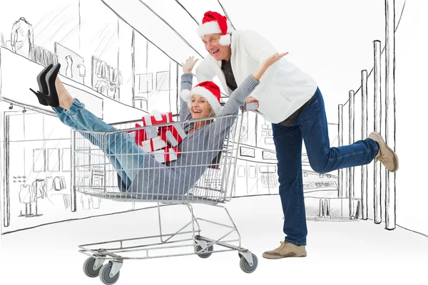 Man pushing wife in trolley with gifts — Stock Photo, Image