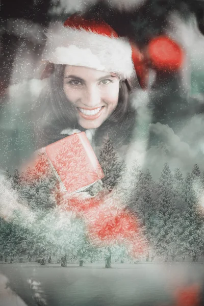 Festive brunette pressing gift at christmas — Stock Photo, Image