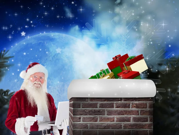 Santa betaalt met credit card op laptop — Stockfoto
