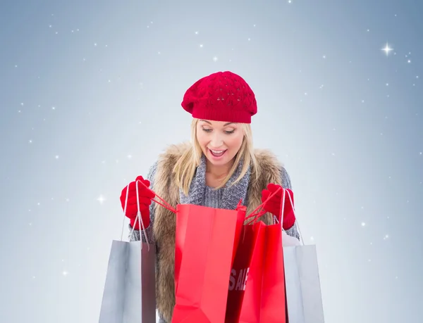 Blondine schaut in Einkaufstüten — Stockfoto