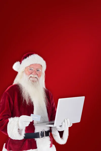 Santa paga com cartão de crédito no laptop — Fotografia de Stock