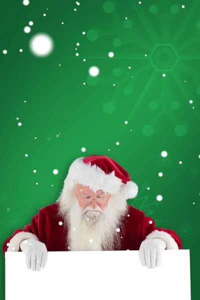 Weihnachtsmann hält Schild und blickt nach unten — Stockfoto