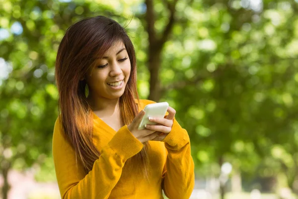 Messaggi di testo donna nel parco — Foto Stock