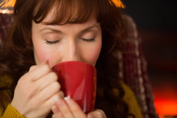 Pelirroja con los ojos cerrados bebiendo bebida caliente — Foto de Stock