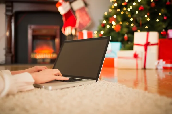 Donna rossa sdraiata sul pavimento utilizzando il computer portatile a Natale — Foto Stock