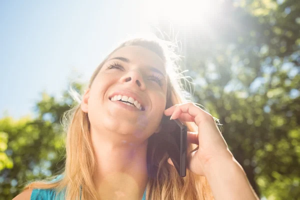 Fit blonde praten over haar smartphone — Stockfoto